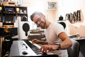 Young man playing electric piano ,recording in studio